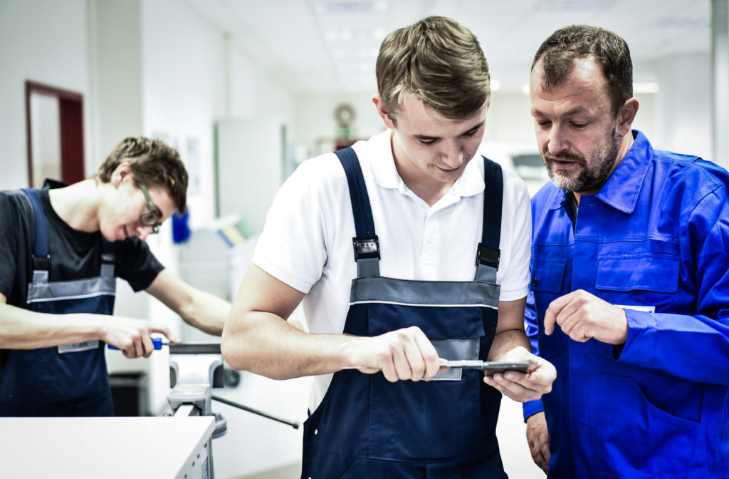 a group of men looking at a tool